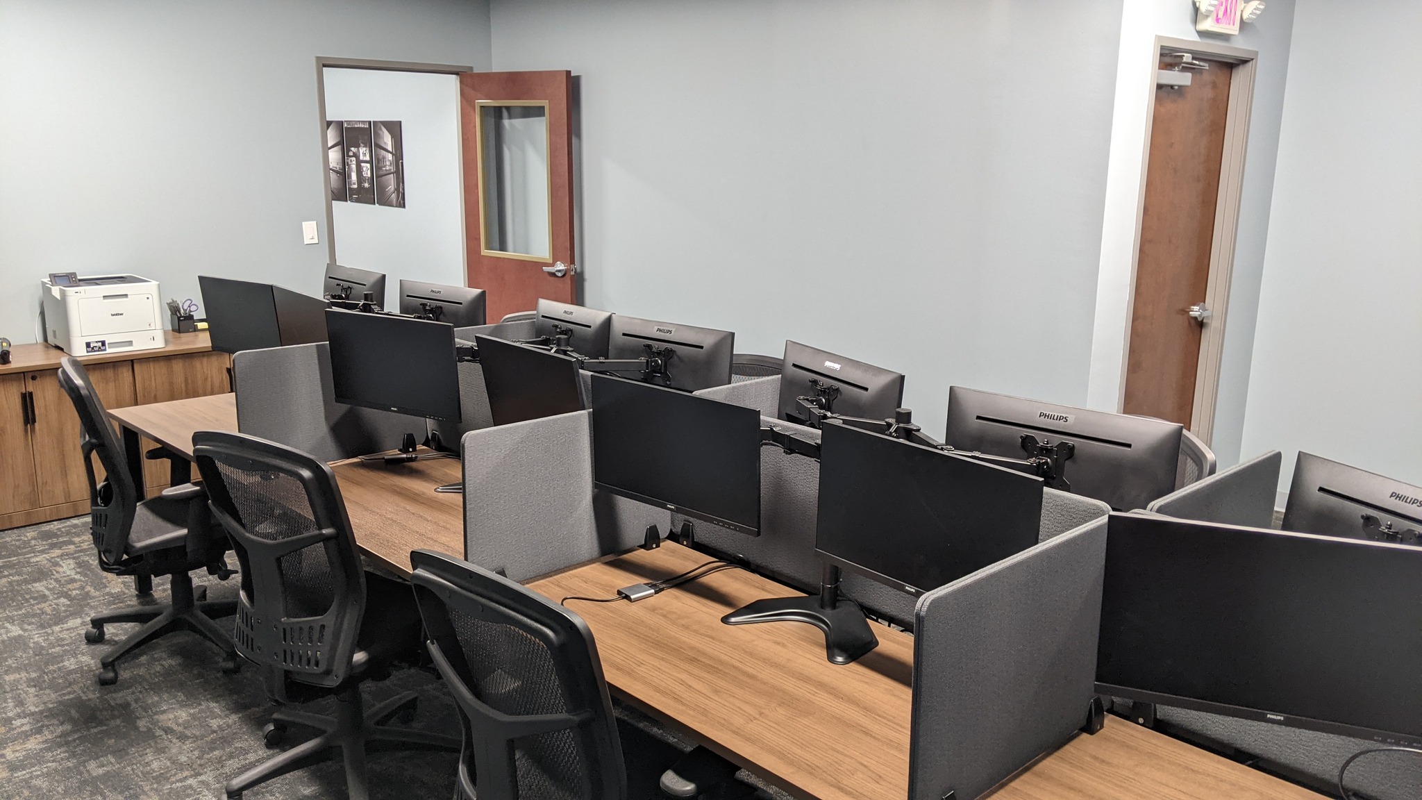 Close-up of a premium walnut wood workstation with a dual-monitor setup at Club Works.